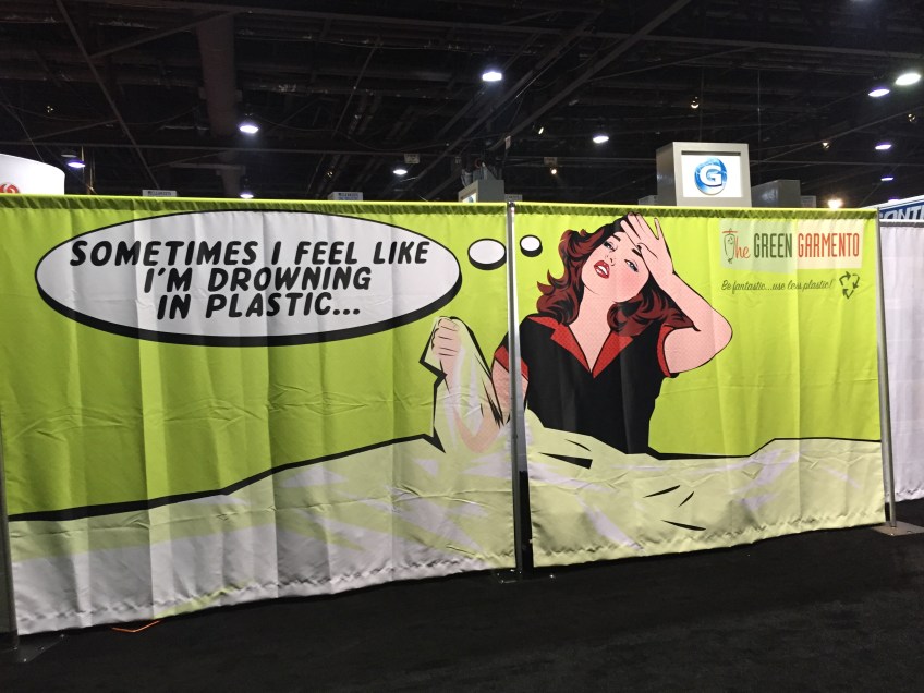 A large green banner depicting a women clutching plastic saying "sometimes I feel like I'm drowning in plastic."