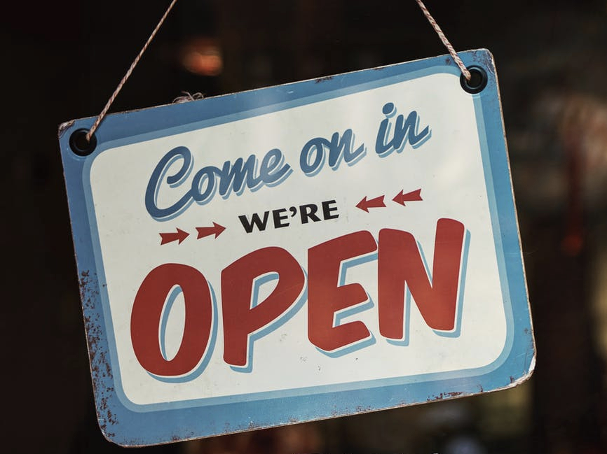 white and blue come on in we ere open signage